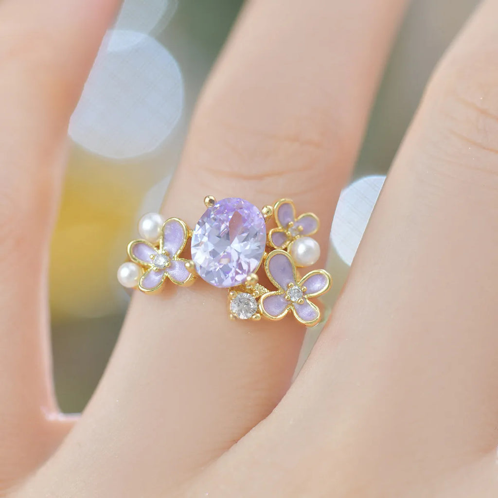 Yellow women's open ring with a flower shape and zircon detailing on a white background.