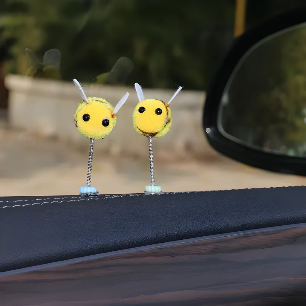 Small black and yellow cartoon bee car decoration with a spring, on a fur ball.