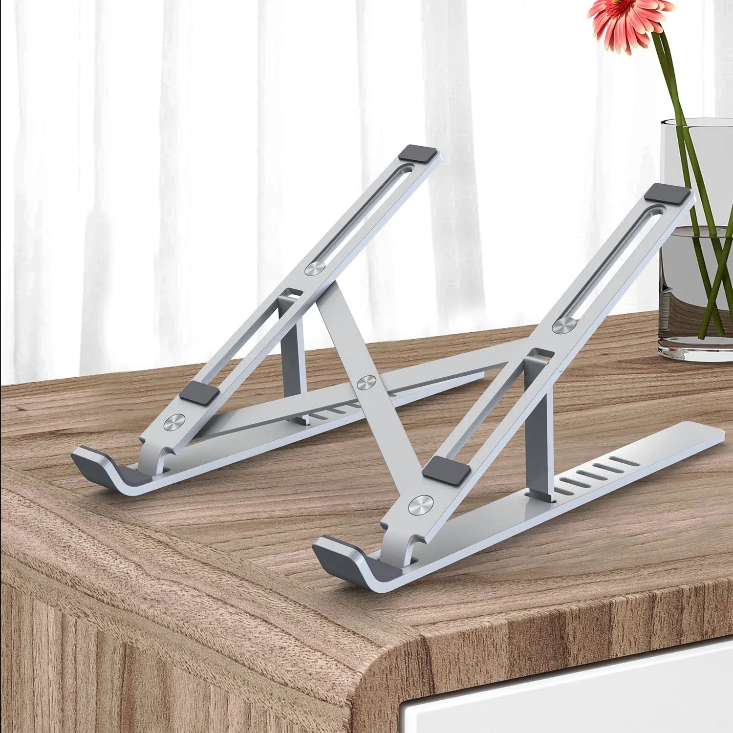 Silver aluminium laptop stand showing six height adjustment positions with laptop elevated