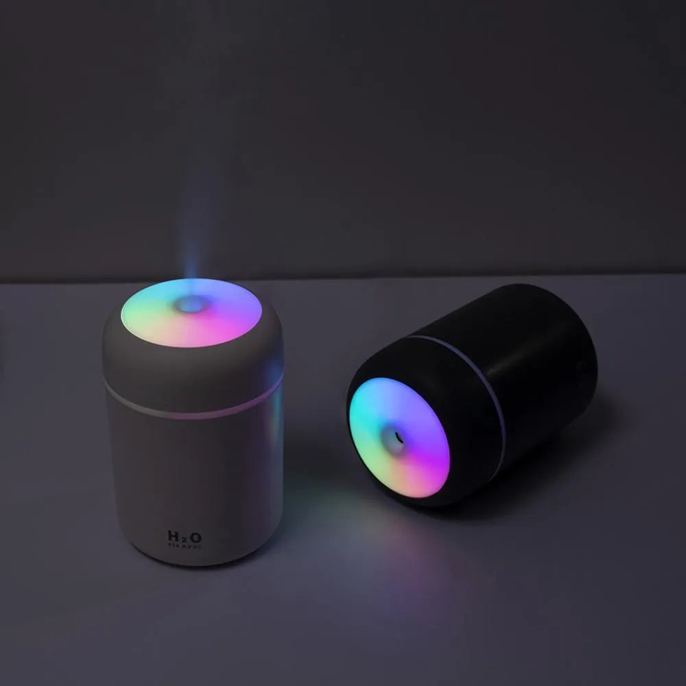 Pink USB desktop humidifier with 300ml water tank and colourful LED lights on wooden desk