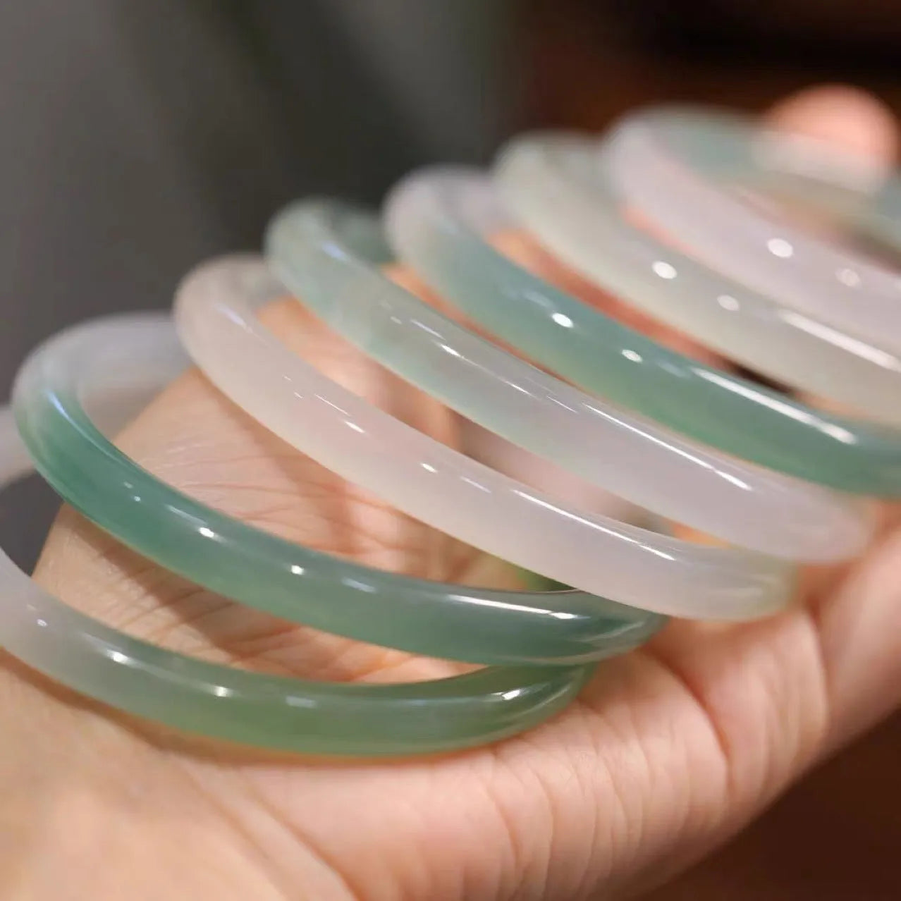 Chalcedony jade bead bracelet with semi-mountain, semi-water pattern on a model's wrist.