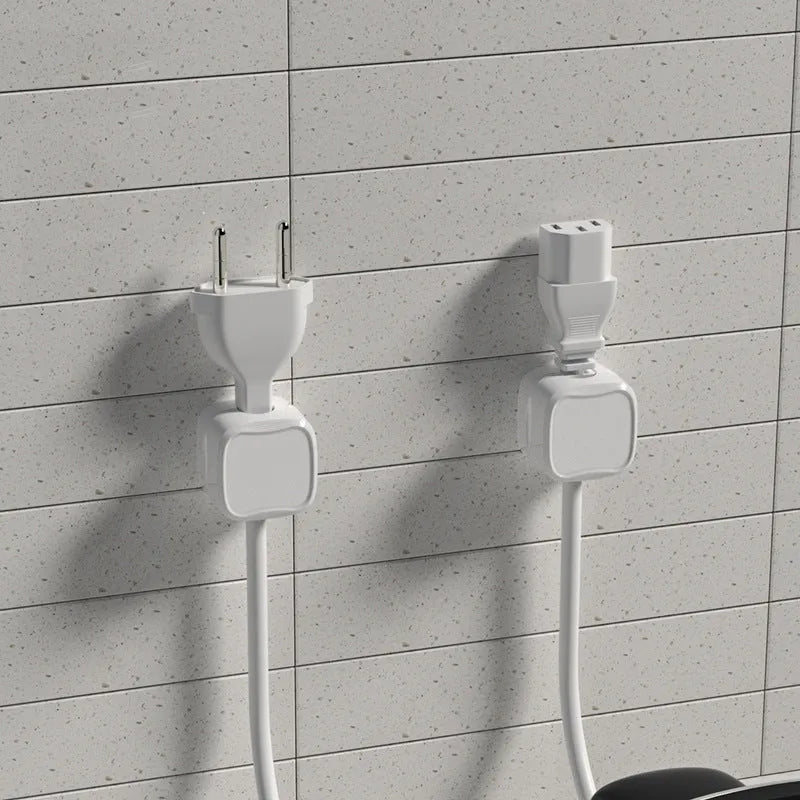 White and black magnetic cable clips with adhesive backing organising multiple cables under a desk