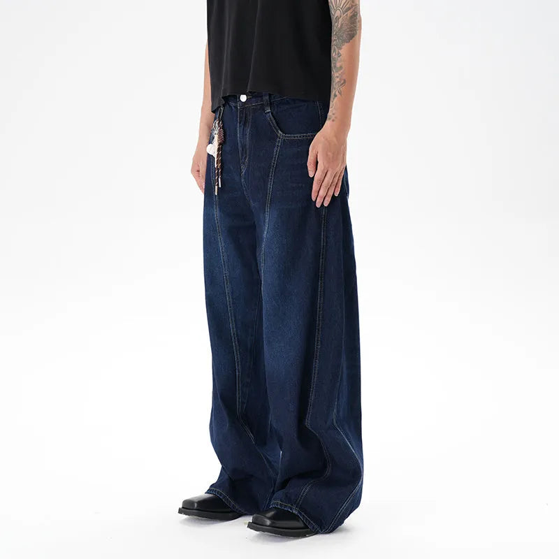 Dark blue wide leg distressed jeans on a hanger showing washed denim fabric and machete cut.