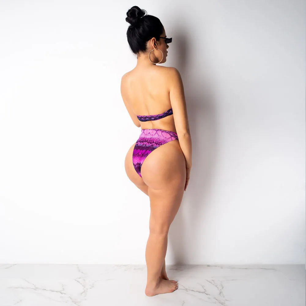 Women's purple snakeskin print bikini set with long sleeves and split shorts laid flat