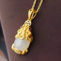 Cartoon character Hetian white jade antique gold pendant necklace with emerald pixiu charm on a chain.