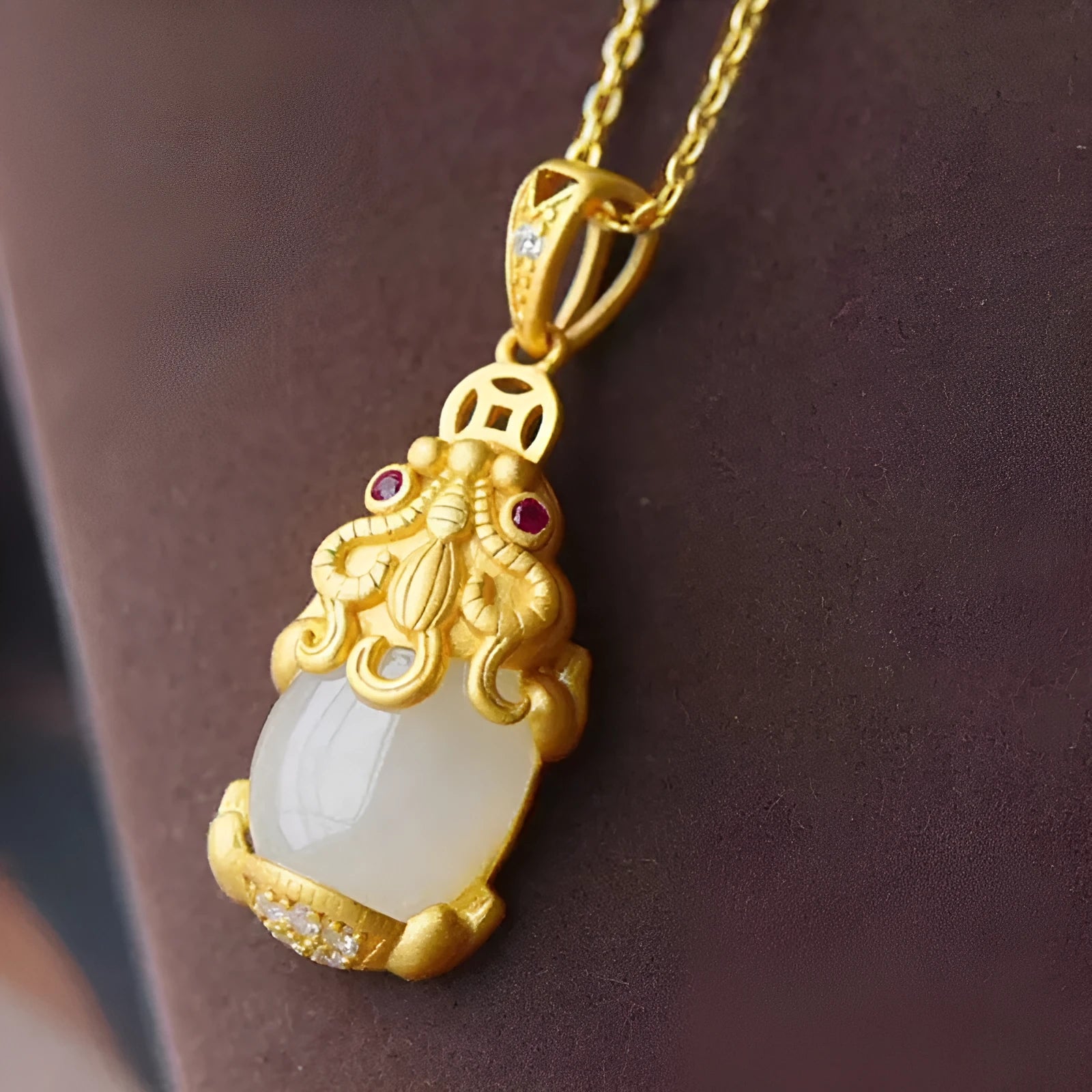 Cartoon character Hetian white jade antique gold pendant necklace with emerald pixiu charm on a chain.
