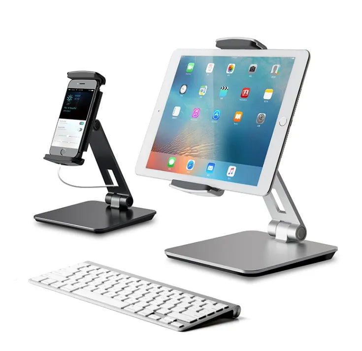Silver foldable aluminium and ABS phone and tablet stand on a desk, showing 360-degree rotation.