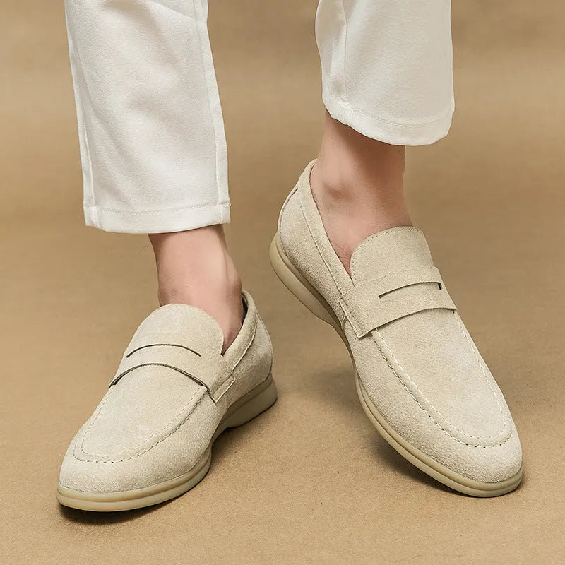 Men's beige leather slip-on shoes with a round toe and mid heel on a rubber sole.