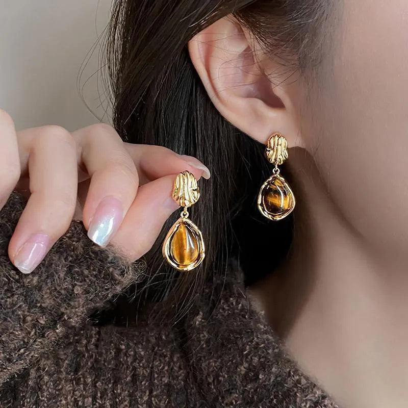 Three pairs of handmade geometric holiday earrings with tassel accents in different designs