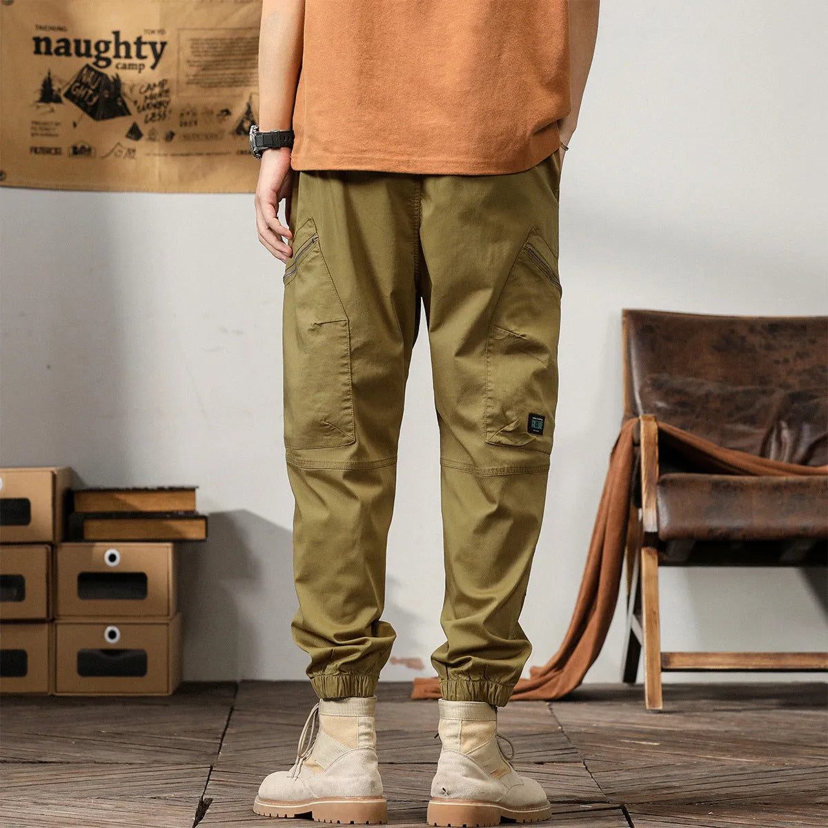 Men's khaki cotton harem pants with tapered ankle cuffs and a loose fit, shown laid flat.