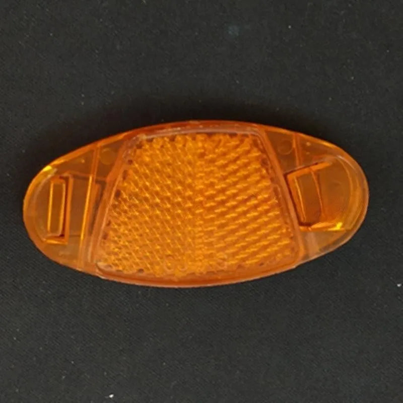 White and yellow plastic bicycle spoke reflectors for front and rear wheel safety.