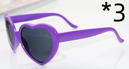 Heart-shaped glow-in-the-dark sunglasses in various vibrant colors, featuring a durable plastic frame and resin lenses for reliable UV protection.