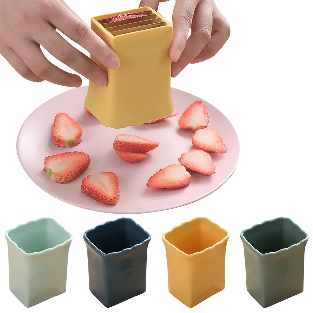 Green stainless steel cup fruit slicer with sliced strawberries on a light background