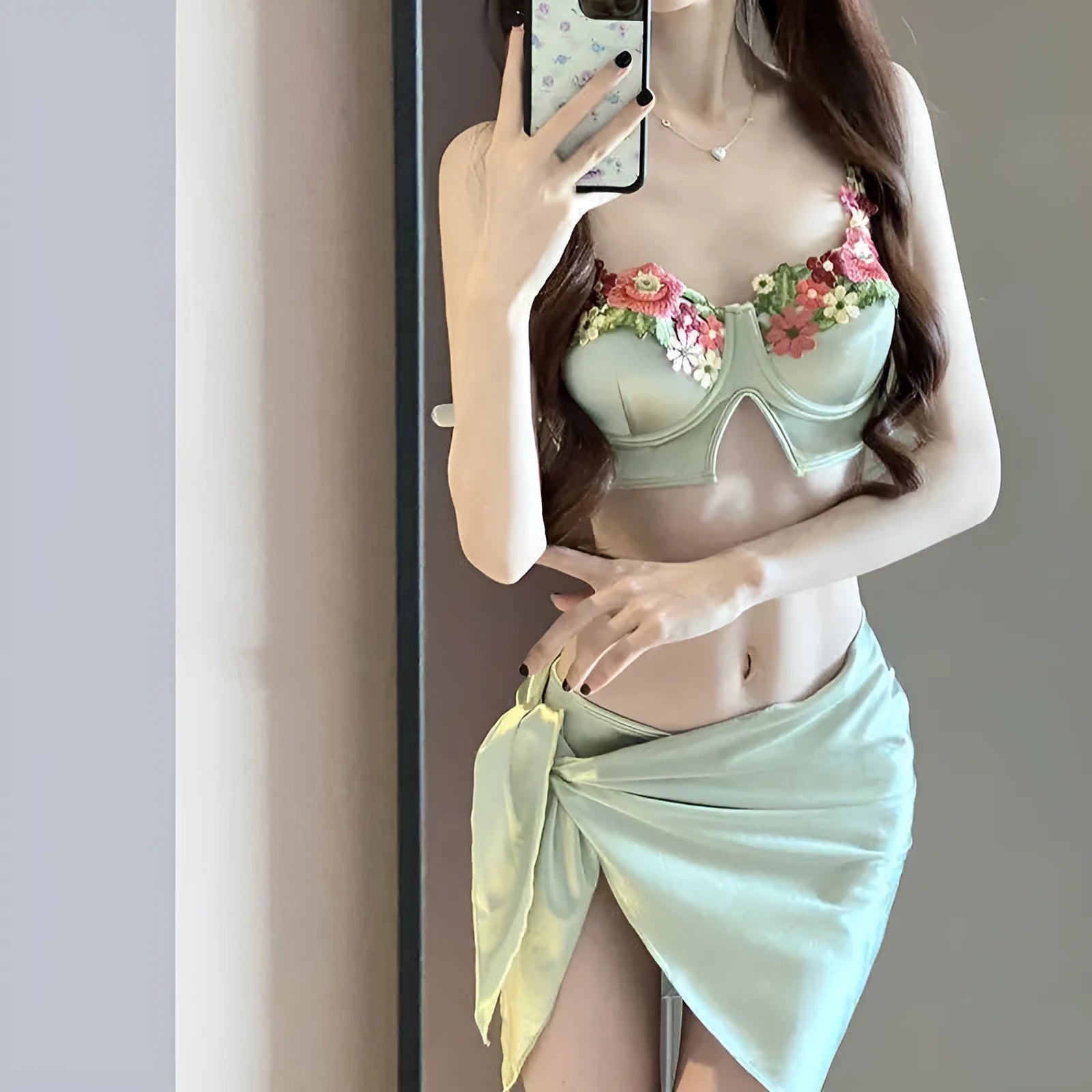 Green women's three-piece bikini swimsuit set with triangle top, briefs, and matching skirt