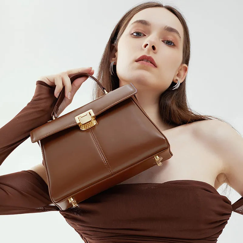 Women's black genuine leather shoulder bag with vachette clasp closure showing internal compartments