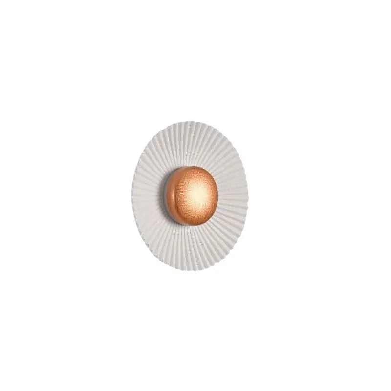 A round, modern wall lamp with an aluminium shade, shown in a two-tone gold and white finish, mounted on a wall.