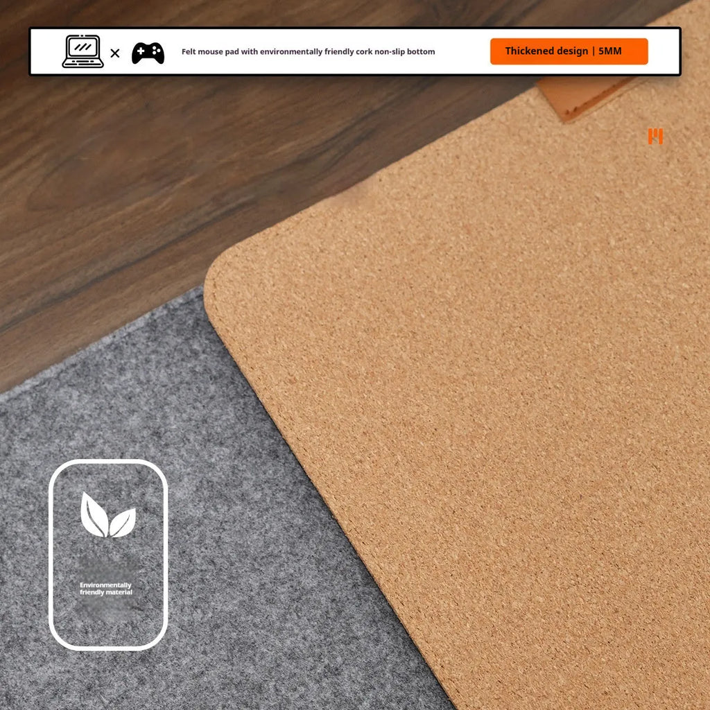A grey and black felt cork desk mat with a mouse on it, shown on a wooden desk.