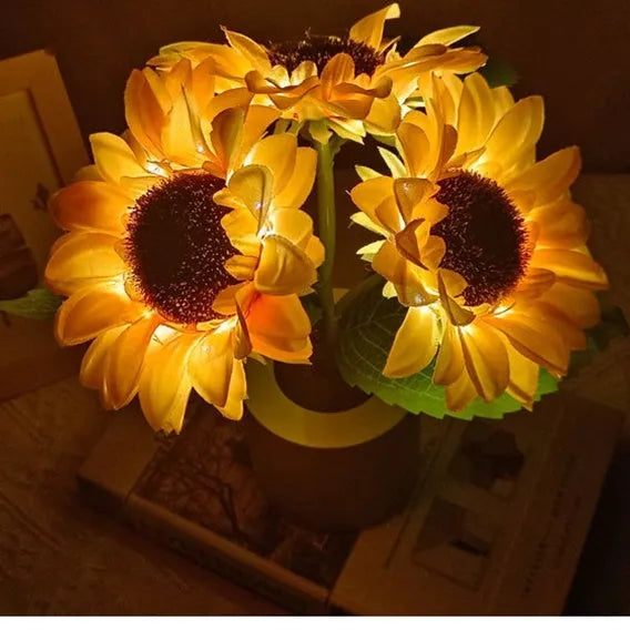 Rechargeable artificial sunflower LED night light on a table with USB charging cable.