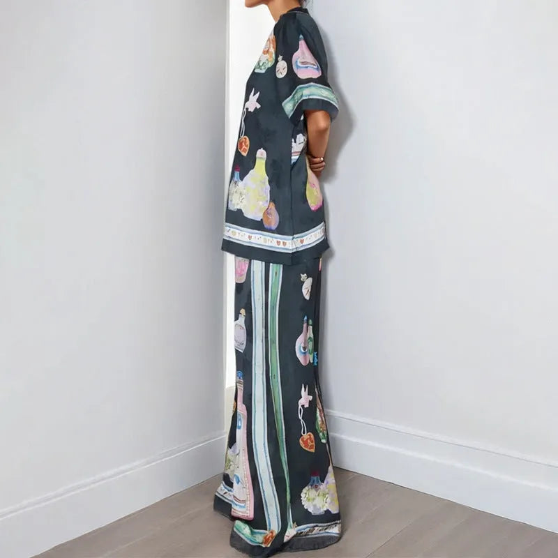 Black women's casual two-piece set with cartoon print, featuring cardigan and matching pants.