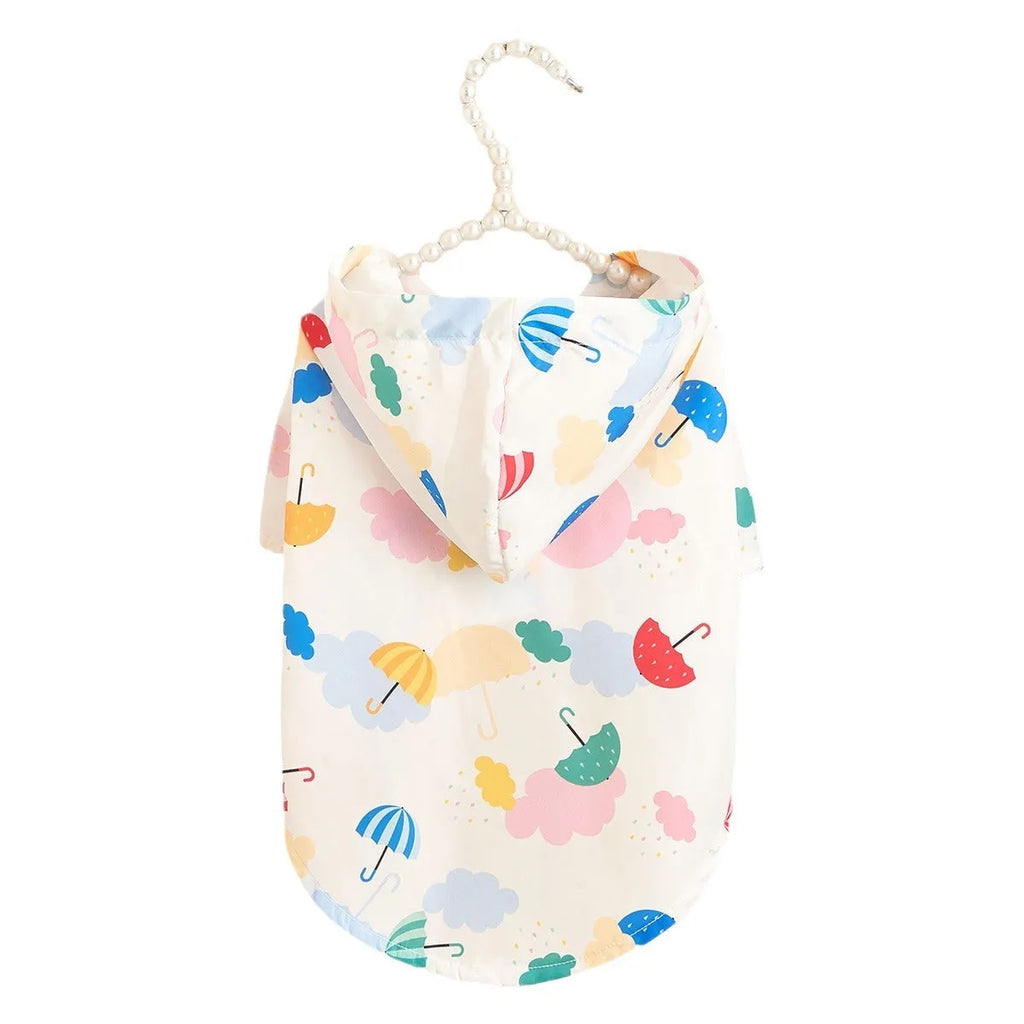 Colourful cartoon umbrella pattern dog raincoat on a model, showing four leg openings and polyester fabric.