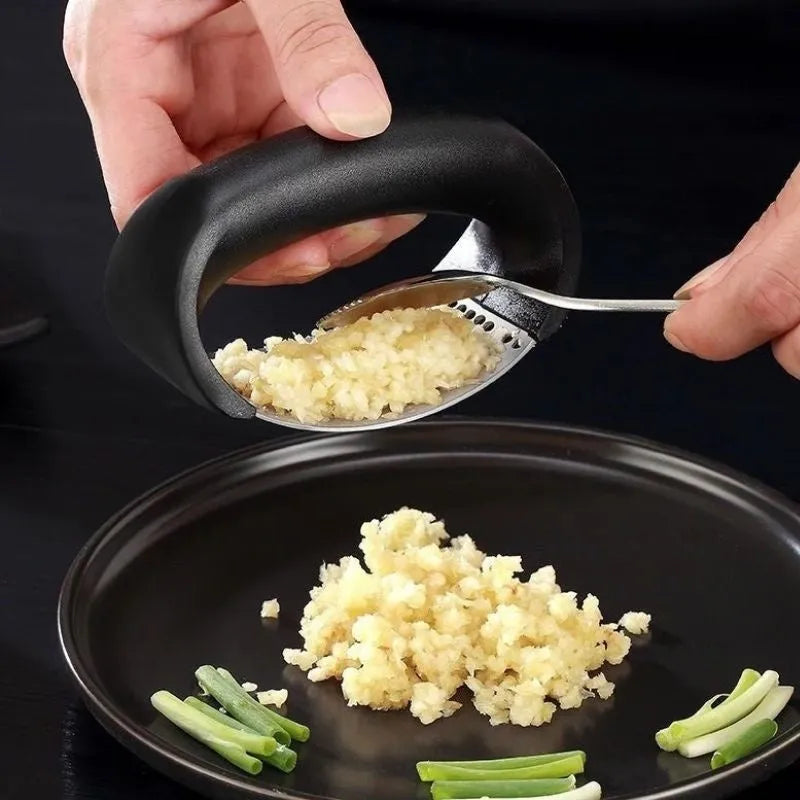 A stainless steel garlic press with a curved design and non-slip ergonomic handle.