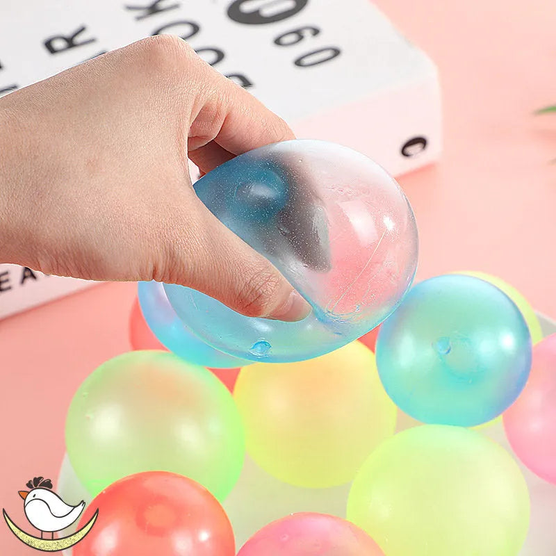 Luminous sticky ball toy in green colour glowing on a dark background, 4.5cm TPR squeeze ball for children