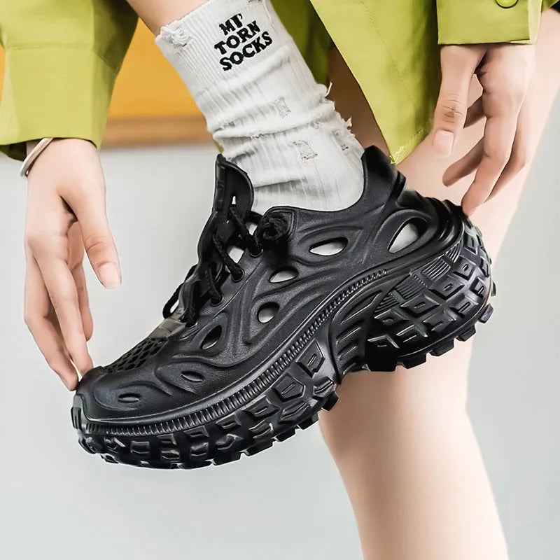 Men's black EVA sandals with a hollow out design and thick sole, shown on a foot.