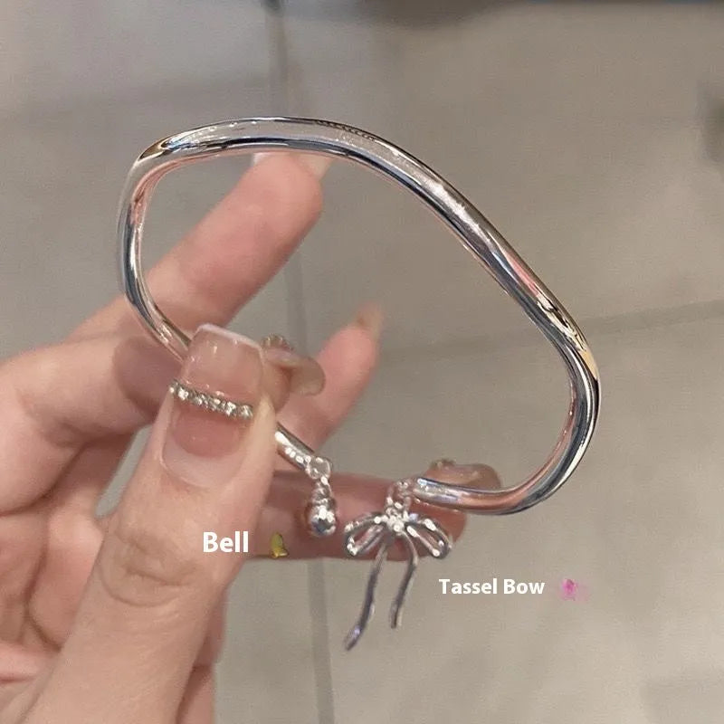 Silver-coloured adjustable bracelet for women featuring a bow charm and a sliding clasp.