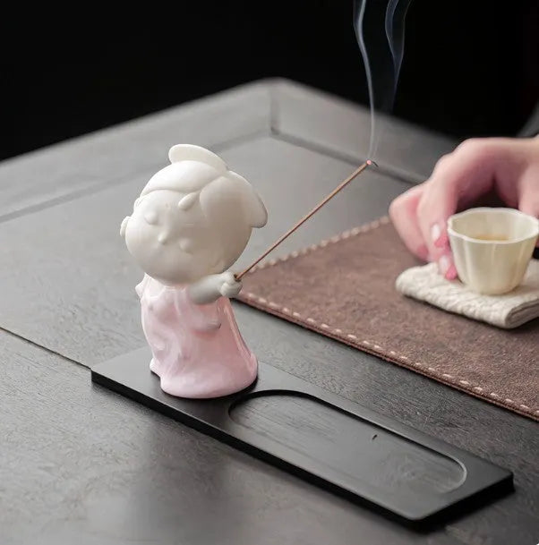 Cute ceramic female court attendant figurine incense burner decoration on a desk.