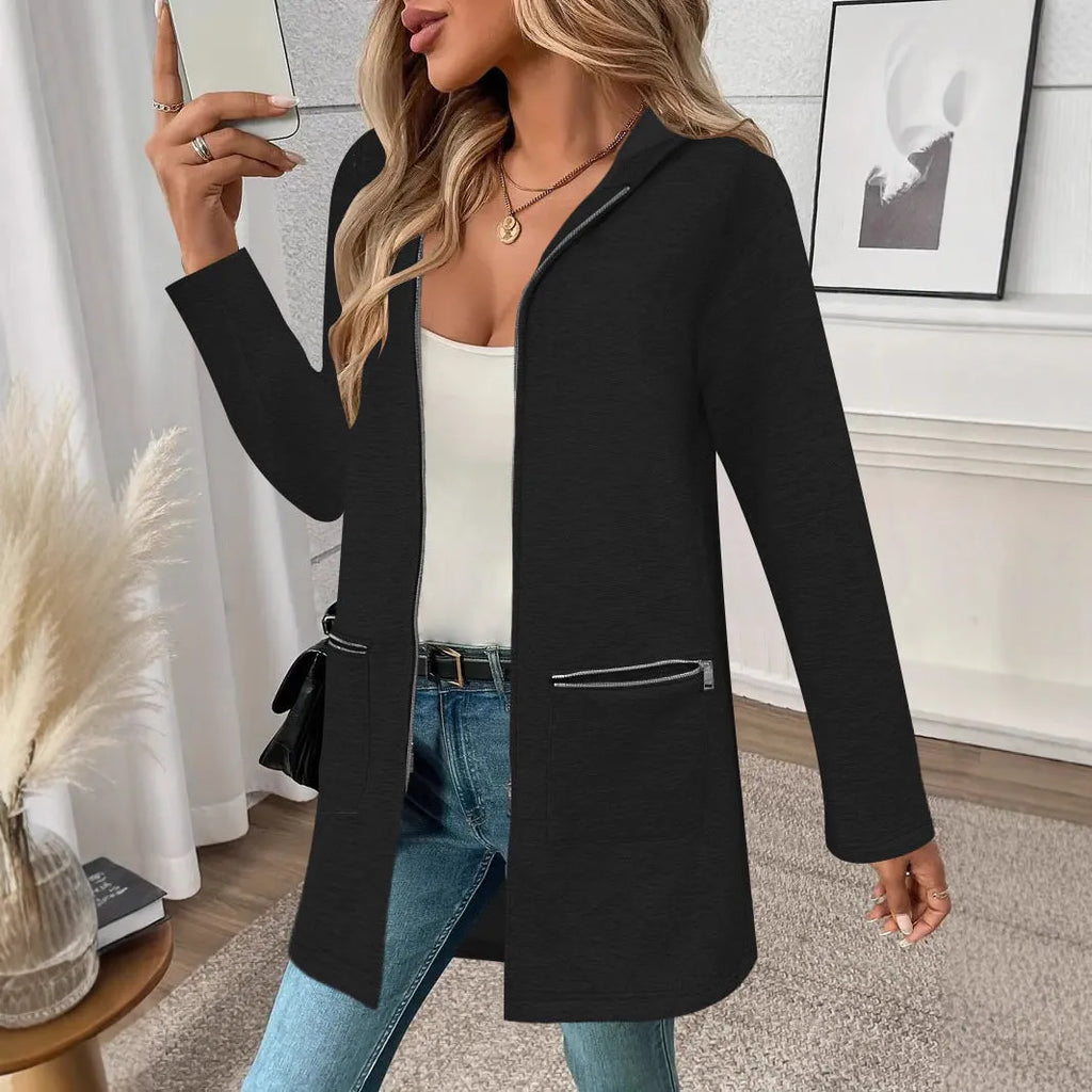 A woman wearing a loose grey mid-length cardigan coat with pockets, casual style.