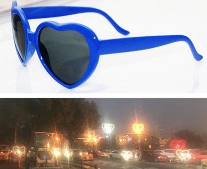 Heart-shaped glow-in-the-dark sunglasses in various vibrant colors, featuring a durable plastic frame and resin lenses for reliable UV protection.