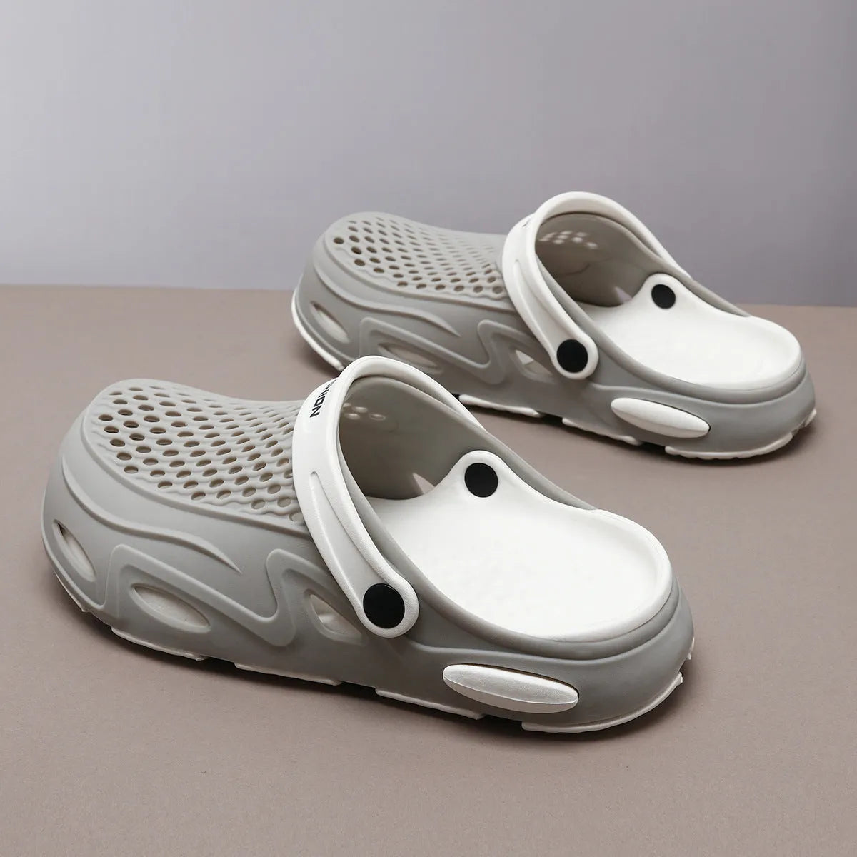 Men's grey closed toe beach slippers with a grid pattern design and a flat sole.