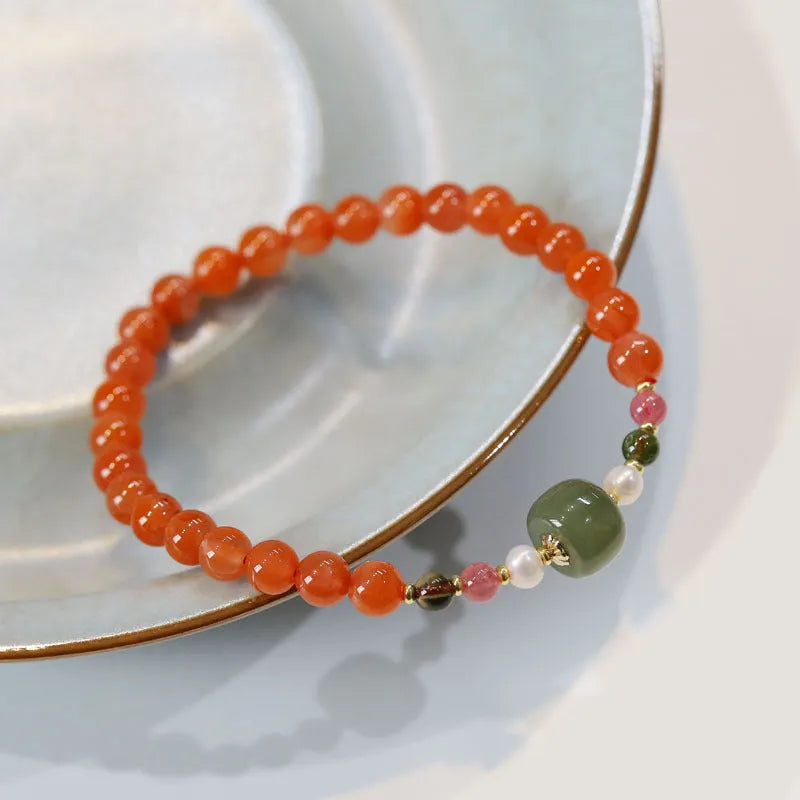 Close-up of a women's bracelet with round cherry red South Red Agate beads in a retro ethnic style.