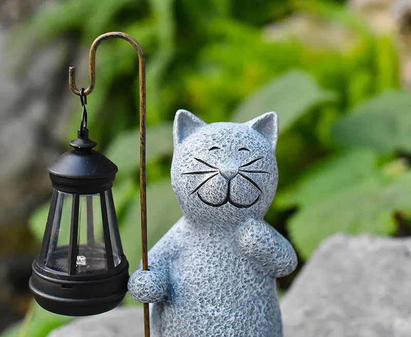 Solar garden light shaped like a kitten lifting a lamp, made from resin for outdoor decoration.