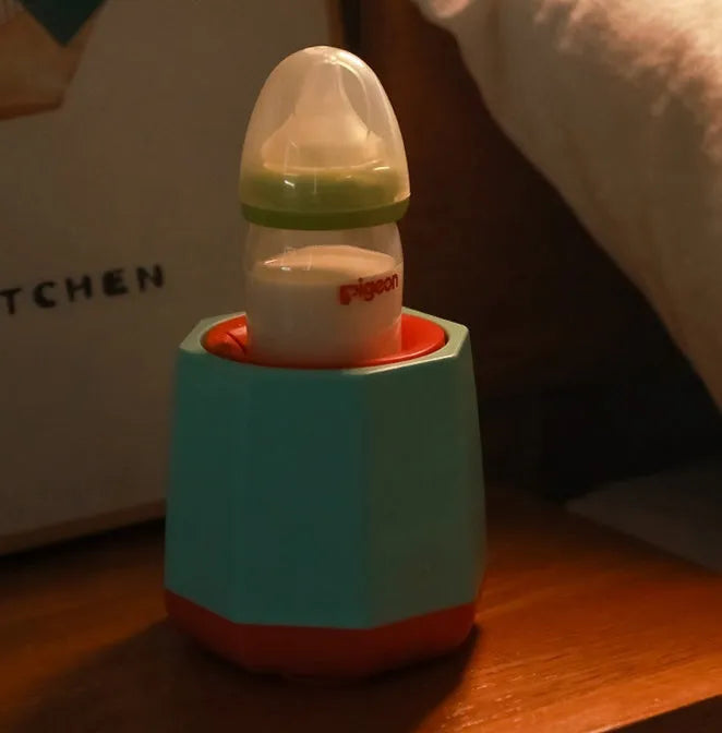 White baby electric milk shaker with green silicone slot holding a round baby bottle, 110x110x110mm