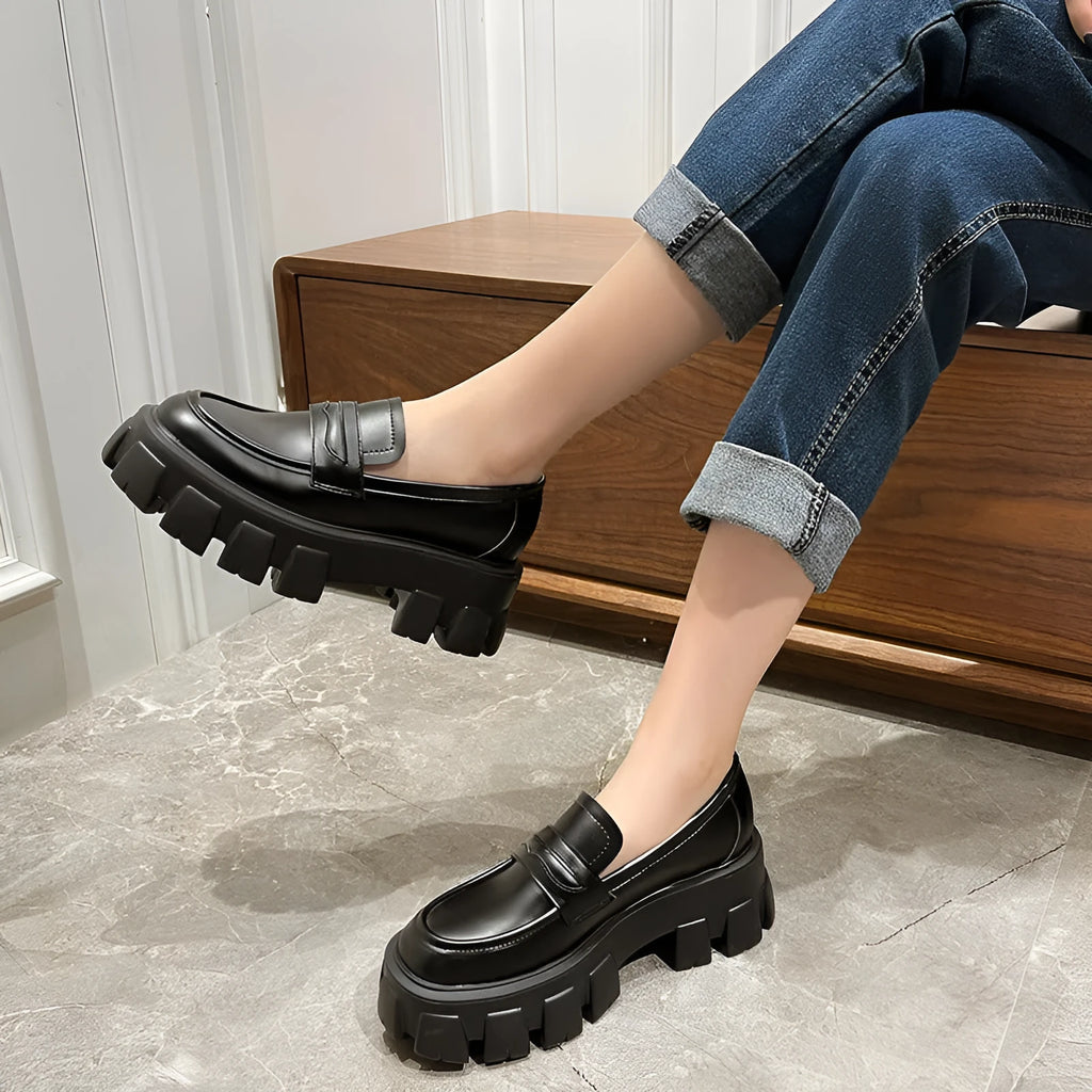 A pair of British style wide fit loafers in patent leather with a rubber sole.