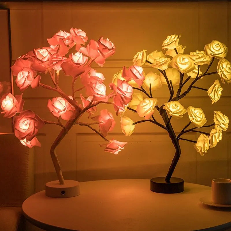 White and red rose flower LED table lamp with bonsai tree and garland lights on a table.