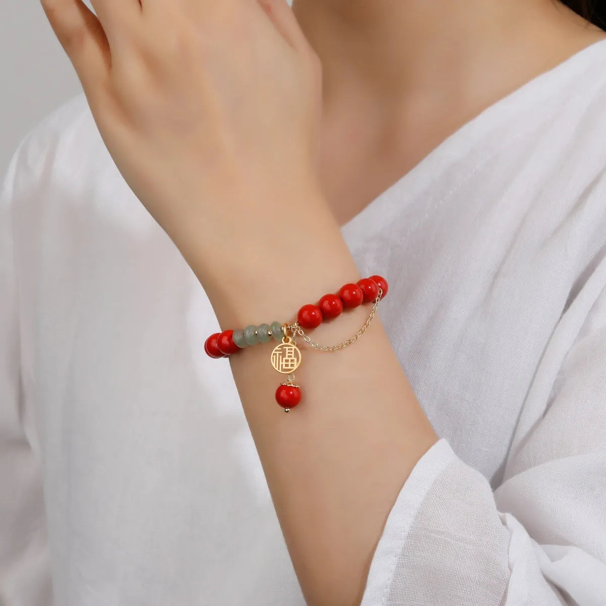 Retro red cinnabar bracelet with carved fu character, jade bead, and leather tassel cord