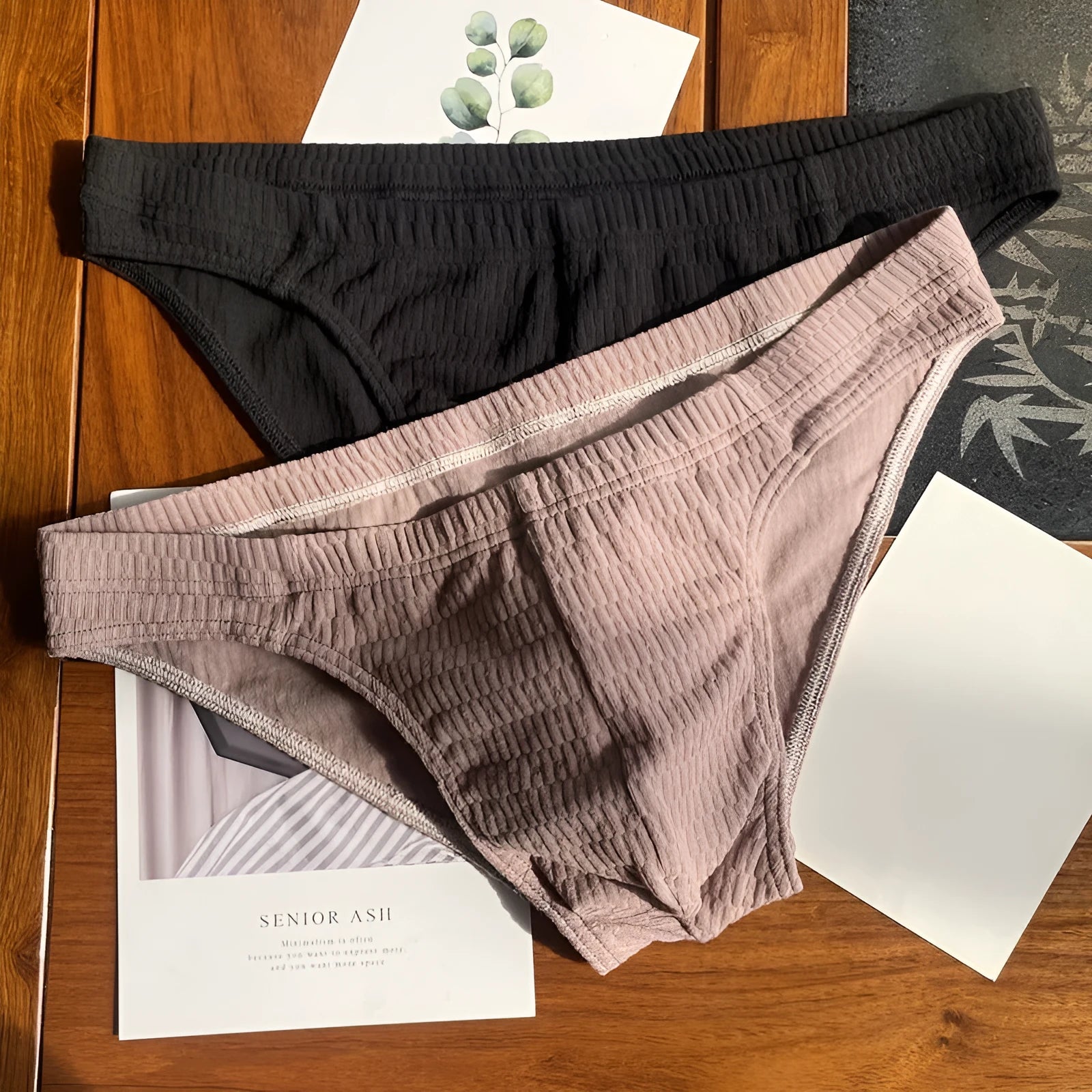 Men's solid colour pure cotton triangle underwear briefs on a mid waist, shown in apricot and black colour options.