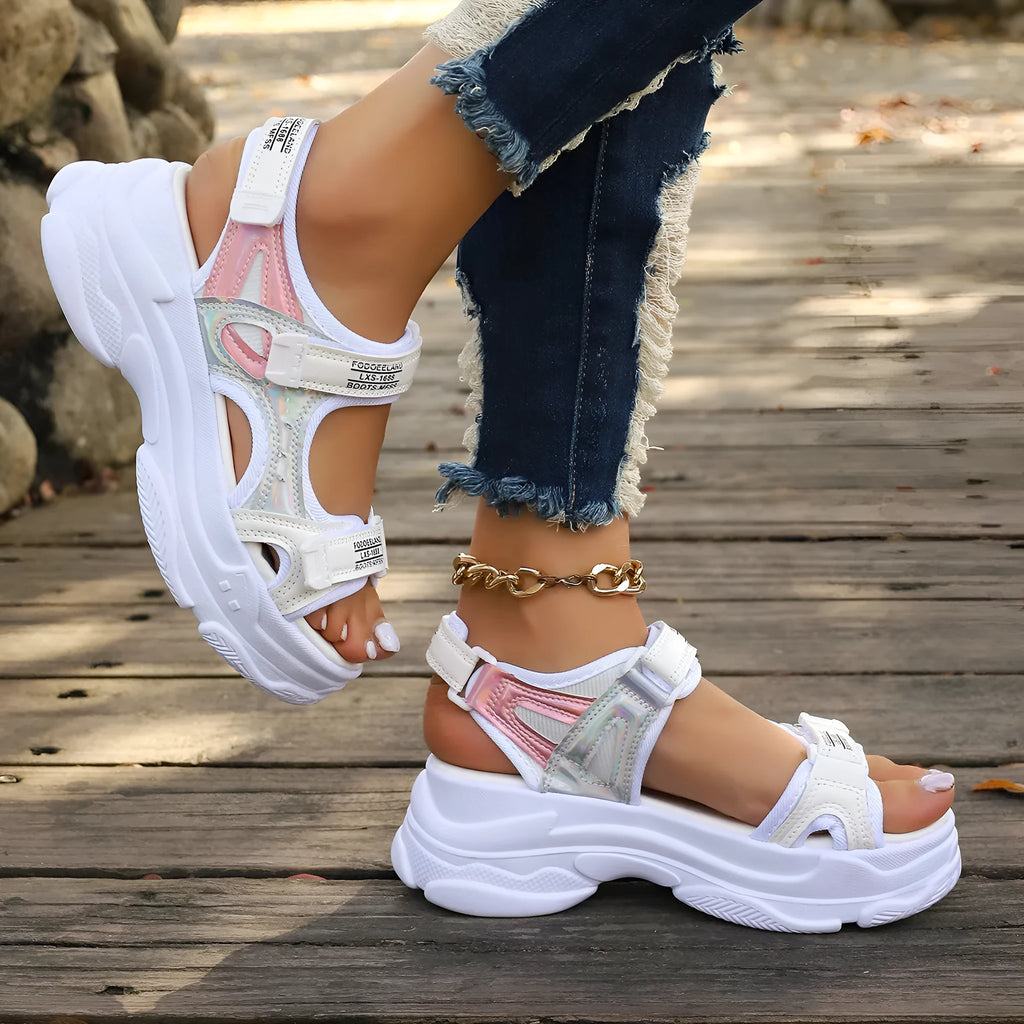 Women's white Roman platform sandals with strap design and rubber sole on a neutral background.