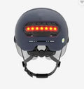 Cycling helmet with integrated red LED brake light on the back, shown in sizes M and L.