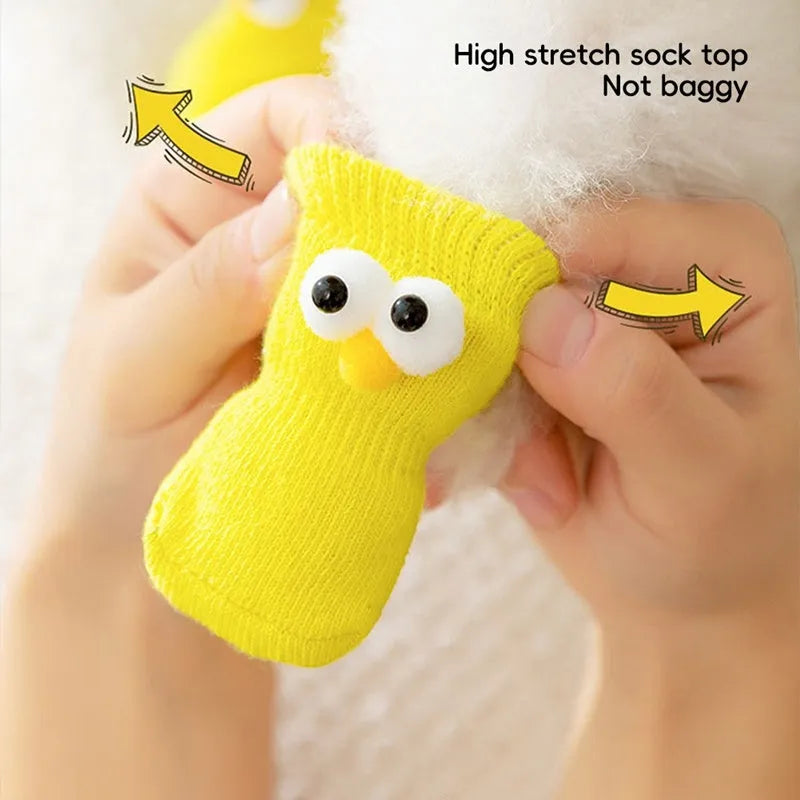 Dog wearing green non-slip socks with cartoon big eyes pattern on wooden floor