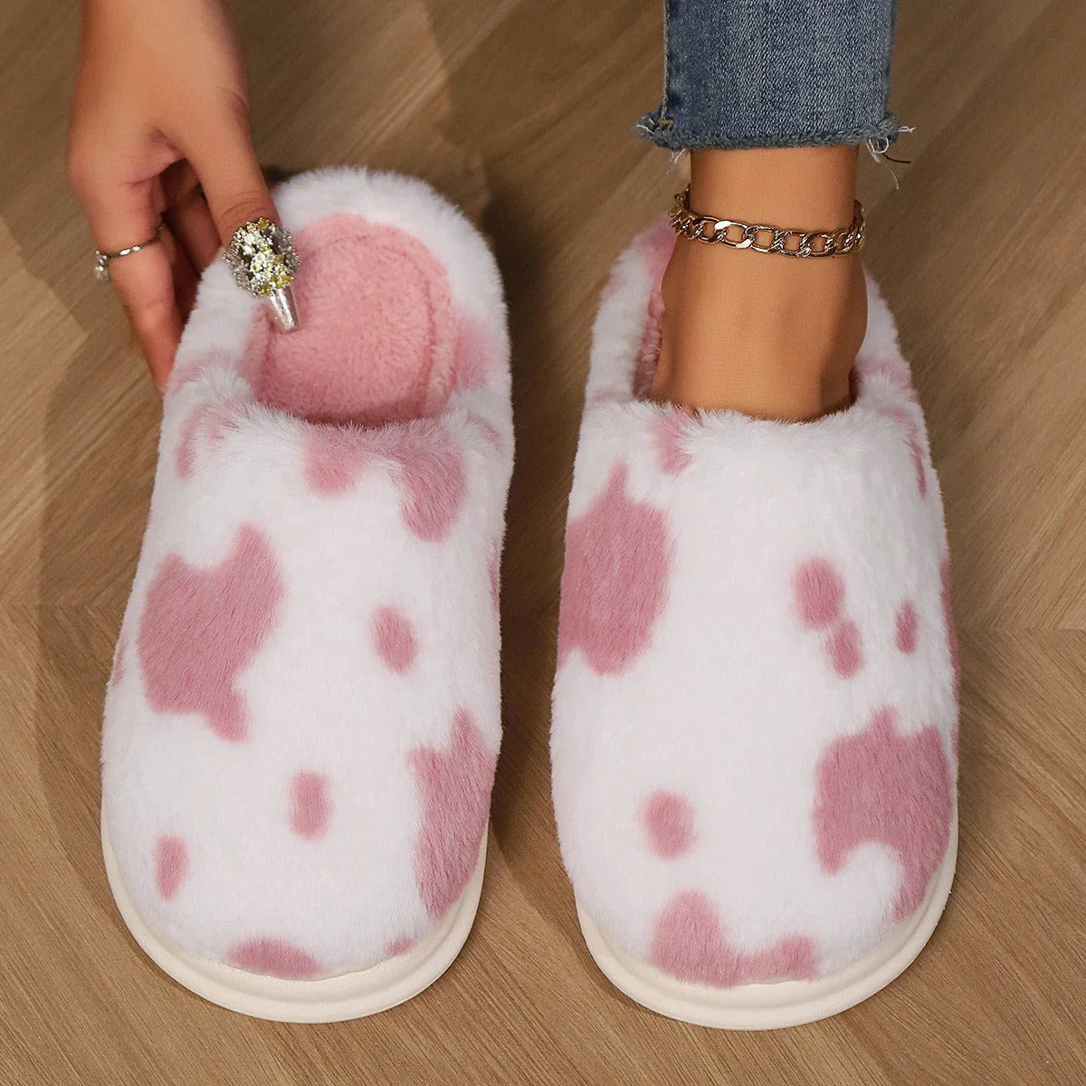 Cozy cow-print plush slippers with soft, fluffy material and non-slip soles for warm, comfortable indoor wear