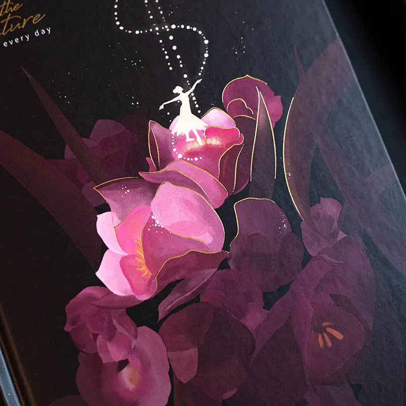 A5 notebook with a luminous cover open to show pages with colour illustrations.