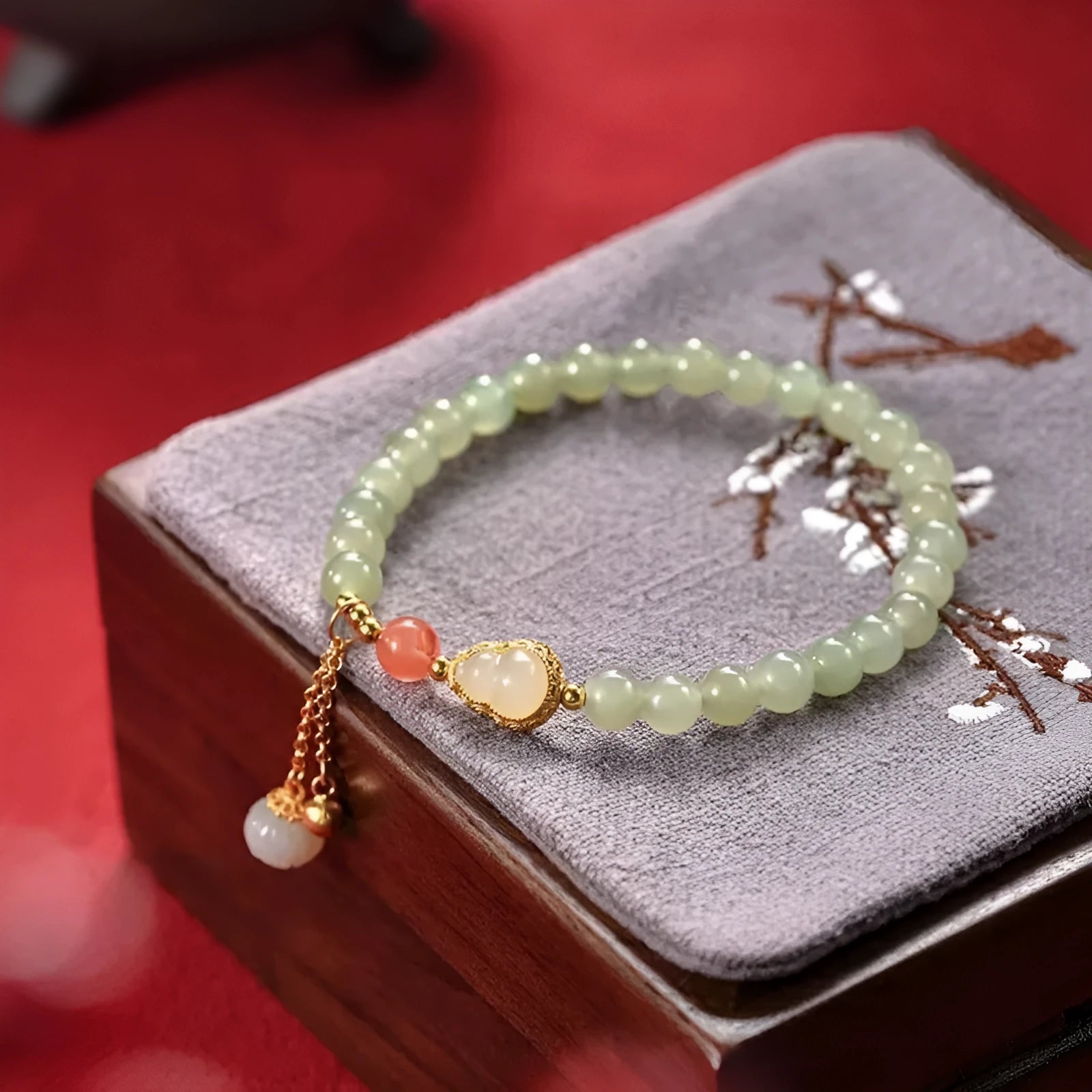 Women's jade bracelet with a 6mm gold-plated gourd charm and engraved fu character.