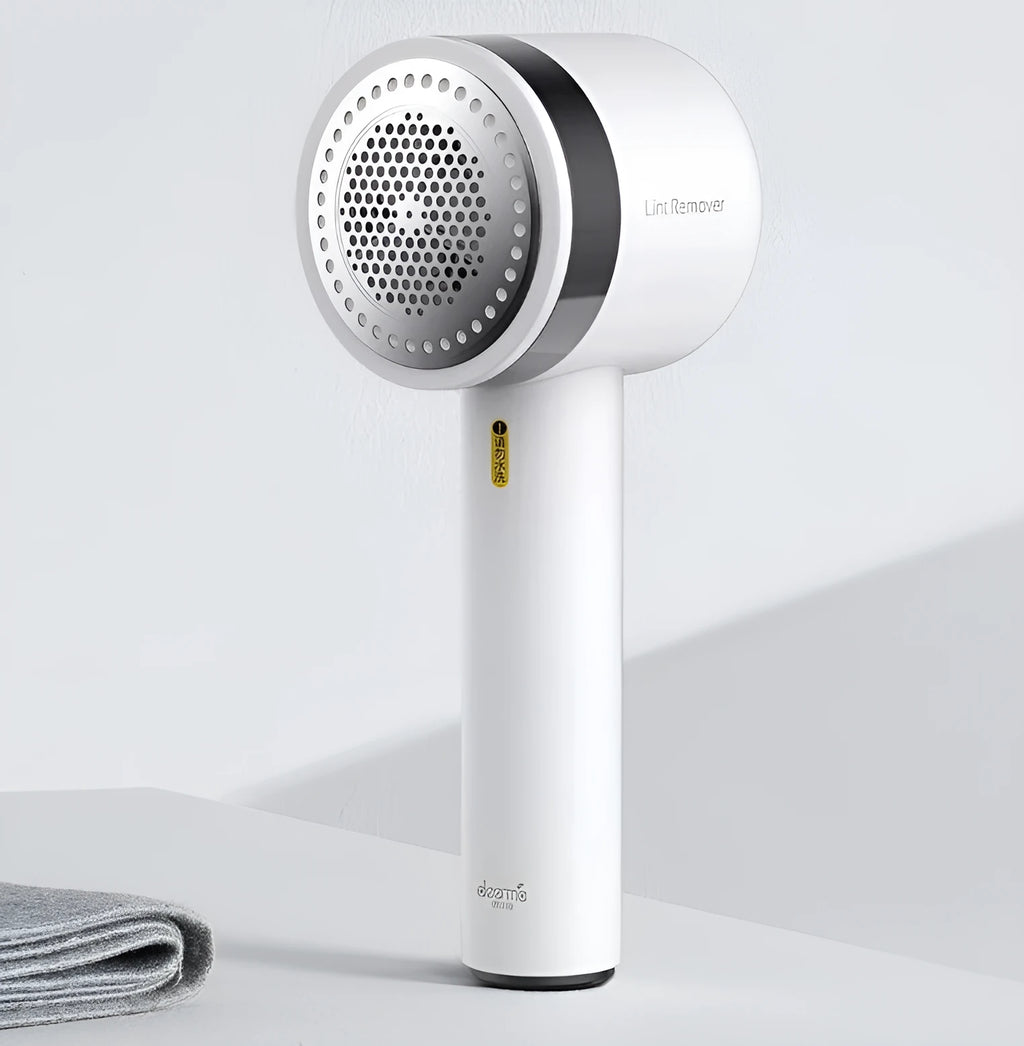 White rechargeable lint remover with hidden hair collection container and detachable three-blade head on white background