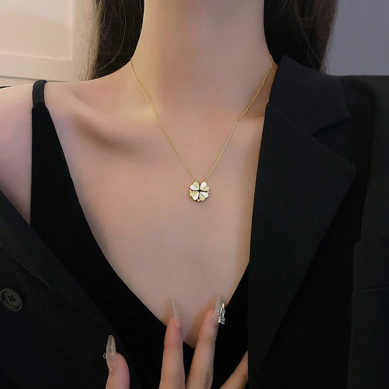 Stainless steel four-leaf clover pendant necklace with crystal heart detail, showcased in various angles and colors