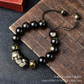 Golden obsidian bead Pi Xiu bracelet with hand-woven design on a wrist.