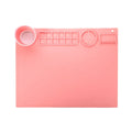 Light blue silicone painting mat with two integrated round bowls, laid flat on a wooden table.