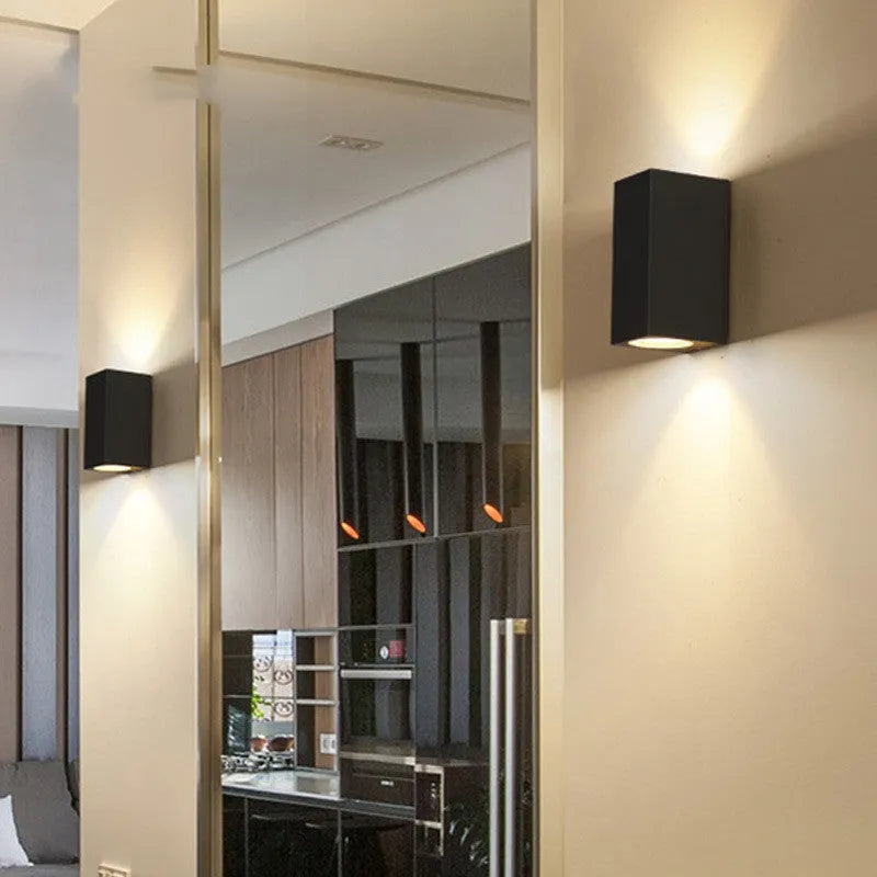 Modern black wall lamp with aluminium body, glass shade, and integrated LED light source.